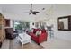 Living room featuring a red couch, bookcase, and access to a patio at 6256 Pennell St, Englewood, FL 34224