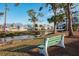 Peaceful waterfront view with a park bench and palm trees at 6800 Placida Rd # 165, Englewood, FL 34224