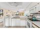 White kitchen with stainless steel appliances and view of living room at 6800 Placida Rd # 165, Englewood, FL 34224