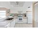 White kitchen with stainless steel appliances and wood cabinets at 6800 Placida Rd # 165, Englewood, FL 34224