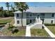 Two-story condo building with stairs, balconies, and lush landscaping at 8050 Memory Ln # 104, Rotonda West, FL 33947