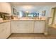 Open concept kitchen with white cabinetry, a dishwasher, and a view to the dining area at 8050 Memory Ln # 104, Rotonda West, FL 33947