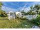Landscaped backyard with a white arbor and fenced pool area at 9261 Saint Catherine Ave, Englewood, FL 34224