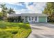 Cute single-story home with a green garage door and well-manicured lawn at 9261 Saint Catherine Ave, Englewood, FL 34224