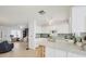 Open kitchen layout with white cabinets and view of the living room at 9261 Saint Catherine Ave, Englewood, FL 34224