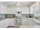 Bright kitchen featuring white cabinets and a gas range at 9261 Saint Catherine Ave, Englewood, FL 34224