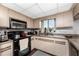 Galley-style kitchen with black appliances and wood cabinets at 9822 Gulfstream Blvd, Englewood, FL 34224