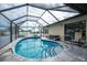 Enclosed kidney-shaped pool with tiled surround at 9822 Gulfstream Blvd, Englewood, FL 34224