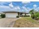 Single-story house with attached garage, landscaping, and a driveway at 11091 Corrigan Ave, Englewood, FL 34224