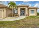 House entrance with double doors, landscaping, and a palm tree at 116 Hercules Dr, Rotonda West, FL 33947