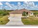 Tan house with three-car garage and lush landscaping at 116 Hercules Dr, Rotonda West, FL 33947