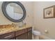 Bathroom with granite countertop, glass sink, and large round mirror at 13048 Creekside Ln, Port Charlotte, FL 33953