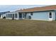 Back of house with large screened sunroom and grassy yard at 13537 Bennett Dr, Port Charlotte, FL 33981