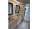 Bathroom with double vanity, large mirror, and shower at 1441 Strada D Oro, Venice, FL 34292