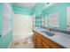 Bathroom with teal walls, tub, and wood vanity at 15120 Payne St, Punta Gorda, FL 33955