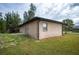 Back of house, tan colored stucco with a small window and french doors at 15120 Payne St, Punta Gorda, FL 33955