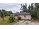 Front view of a single story house with a green roof and palm trees at 15120 Payne St, Punta Gorda, FL 33955