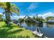 Private boat lift on a canal with lush green landscaping at 15180 Lyneburg Ave, Port Charlotte, FL 33981