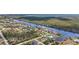Aerial shot showing the home's waterfront location and proximity to neighboring houses and canal at 15361 Visalia Rd, Port Charlotte, FL 33981