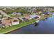 A high angle shows the home with a screened-in pool, solar panels and private dock on the canal at 15361 Visalia Rd, Port Charlotte, FL 33981