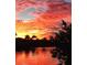 Striking water view showcasing a colorful sunset reflecting on the water near palm trees and foliage at 15361 Visalia Rd, Port Charlotte, FL 33981