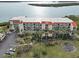 Aerial view of waterfront condo building with lush landscaping and parking at 1751 Beach Rd # 403, Englewood, FL 34223