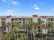 Exterior view of building with palm trees and water views at 1751 Beach Rd # 403, Englewood, FL 34223
