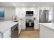 Modern kitchen with white cabinets, stainless steel appliances, and a large island at 1751 Beach Rd # 403, Englewood, FL 34223