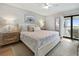 Main bedroom with a king-size bed, light wood nightstands, and water view at 1751 Beach Rd # 403, Englewood, FL 34223