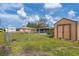 Fenced backyard with shed and green lawn at 1780 Morning Dove Ln, Englewood, FL 34224