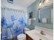 Bathroom with shower/tub combo, floral shower curtain, and white vanity at 1780 Morning Dove Ln, Englewood, FL 34224