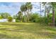 Expansive grassy backyard with tropical landscaping at 217 Wayne Rd, Rotonda West, FL 33947