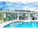 Inviting pool area with screened enclosure, comfortable seating, and a grill at 217 Wayne Rd, Rotonda West, FL 33947