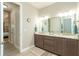 Double vanity bathroom with granite countertop and large mirror at 226 Rotonda N Blvd, Rotonda West, FL 33947