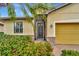 Inviting exterior with a yellow garage door and lush landscaping at 2482 Arugula Dr, North Port, FL 34289