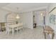 Formal dining room with white table, chairs, and a beautiful chandelier at 26837 Weiskopf Dr, Englewood, FL 34223