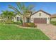 One-story home with a charming facade, lush landscaping, and brick driveway at 26837 Weiskopf Dr, Englewood, FL 34223