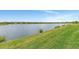 Tranquil lakefront property with clear water and green grass at 26837 Weiskopf Dr, Englewood, FL 34223