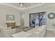 Bright living room with white sofas, sliding glass doors, and wood-look floors at 26837 Weiskopf Dr, Englewood, FL 34223