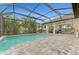 Spacious pool area with covered patio, screened enclosure, and paver deck at 26837 Weiskopf Dr, Englewood, FL 34223