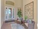 Front entry with glass door, wicker chairs, and decorative wall art at 2744 Mill Creek Rd, Port Charlotte, FL 33953