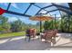 Spacious patio with covered lanai, comfortable seating, and umbrella for shade at 2744 Mill Creek Rd, Port Charlotte, FL 33953