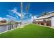 Artificial turf backyard with wooden privacy fence and waterfront views at 3015 Curry Ter, Port Charlotte, FL 33981