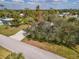 An aerial view showcases the home with a long driveway, mature trees, and a spacious front yard at 3568 Middletown St, Port Charlotte, FL 33952