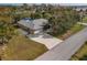 A scenic aerial view displays the home with a large driveway and surrounding lush landscaping near a pond at 3568 Middletown St, Port Charlotte, FL 33952