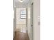 Hallway transitioning from wood laminate to tile, offering a glimpse of natural light at 3568 Middletown St, Port Charlotte, FL 33952