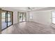 Bright living room with wood laminate flooring and screened patio access, perfect for entertaining at 3568 Middletown St, Port Charlotte, FL 33952