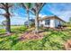 Home's backyard features a screened patio, lush lawn, and mature trees at 4233 Grosse Pointe Dr, Port Charlotte, FL 33953
