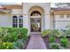 Elegant entryway with double doors and a brick walkway, enhancing the home's charm at 4233 Grosse Pointe Dr, Port Charlotte, FL 33953