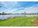 Serene lake view with grassy area and blue sky at 4233 Grosse Pointe Dr, Port Charlotte, FL 33953